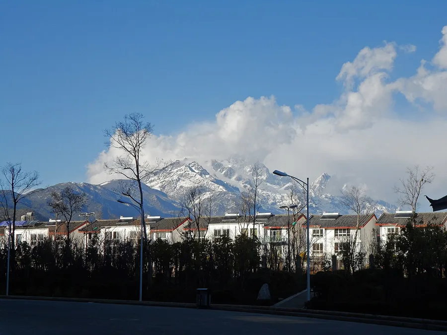 Montañas nevadas detrás de los edificios de Lijiang, Yunnan